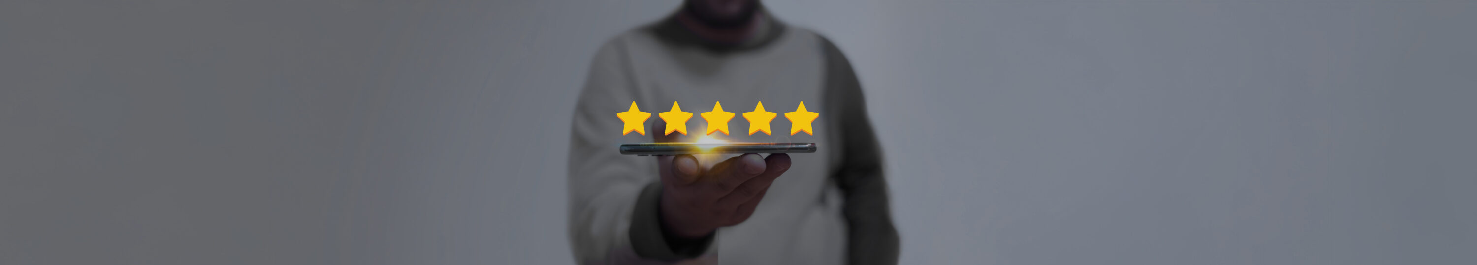 Hand,Holding,A,Smartphone,With,Five,Glowing,Golden,Stars,Floating